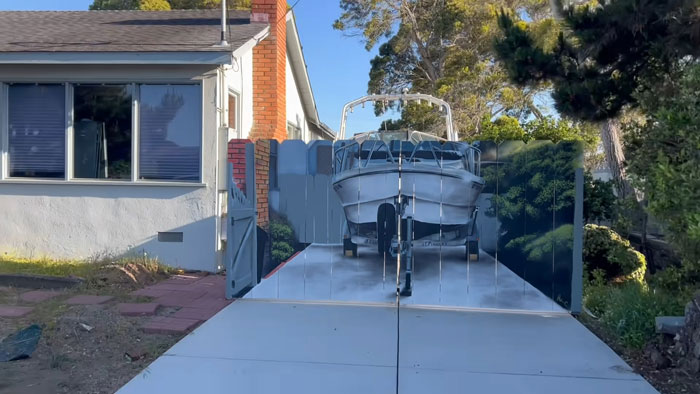 City Forces Guy To Build A Fence To Hide His Boat, He Complies Maliciously And Paints A Mural On It