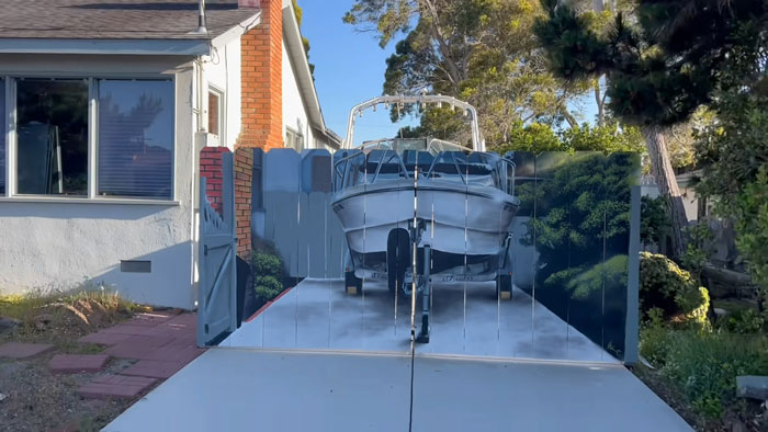 City Forces Guy To Build A Fence To Hide His Boat, He Complies Maliciously And Paints A Mural On It