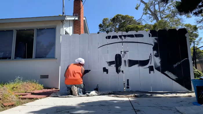 City Forces Guy To Build A Fence To Hide His Boat, He Complies Maliciously And Paints A Mural On It