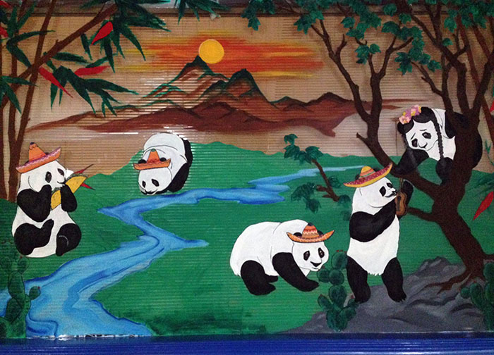 Mural of pandas wearing sombreros enjoying nature by a river, showcasing creative bar and restaurant décor ideas.