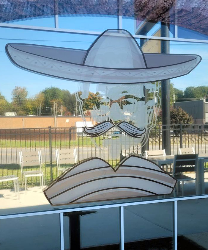 Window decal of a man with a mustache wearing a sombrero, featured at one of the bars and restaurants with brilliant ideas.