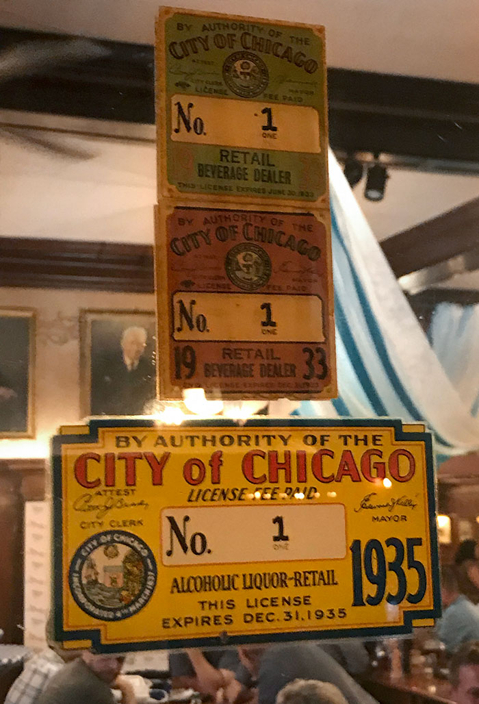 Vintage City of Chicago liquor retail licenses displayed in a bar highlighting unique bars and restaurants ideas.