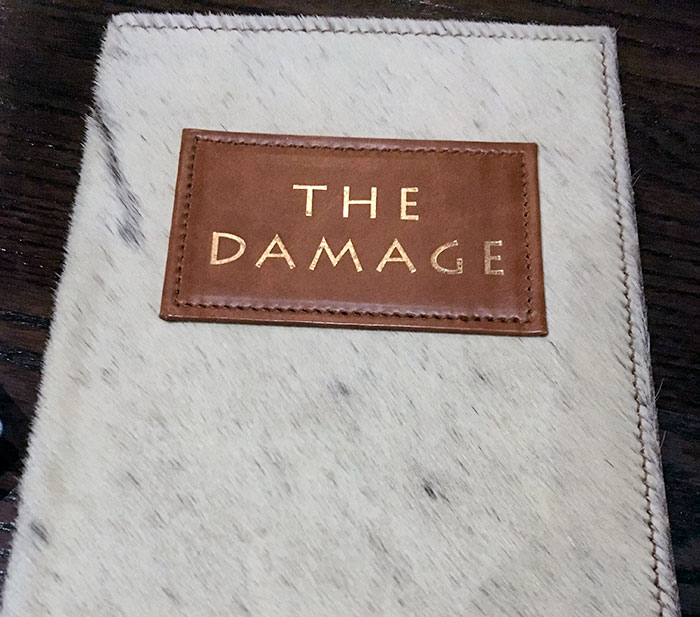 Menu cover of The Damage bar, showcasing creative design at innovative bars and restaurants with brilliant ideas.
