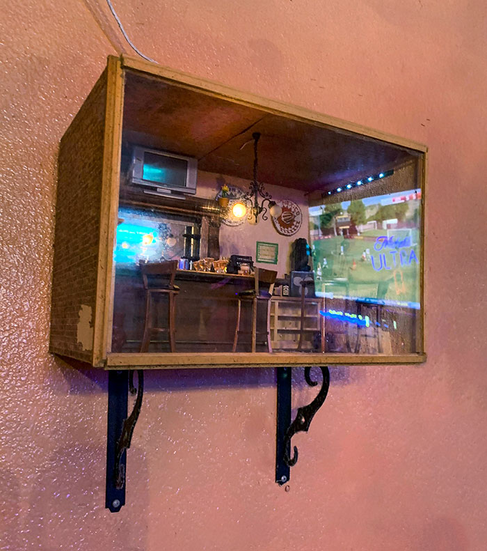 Miniature bar display mounted on a wall, showcasing creative and brilliant bar and restaurant design ideas.