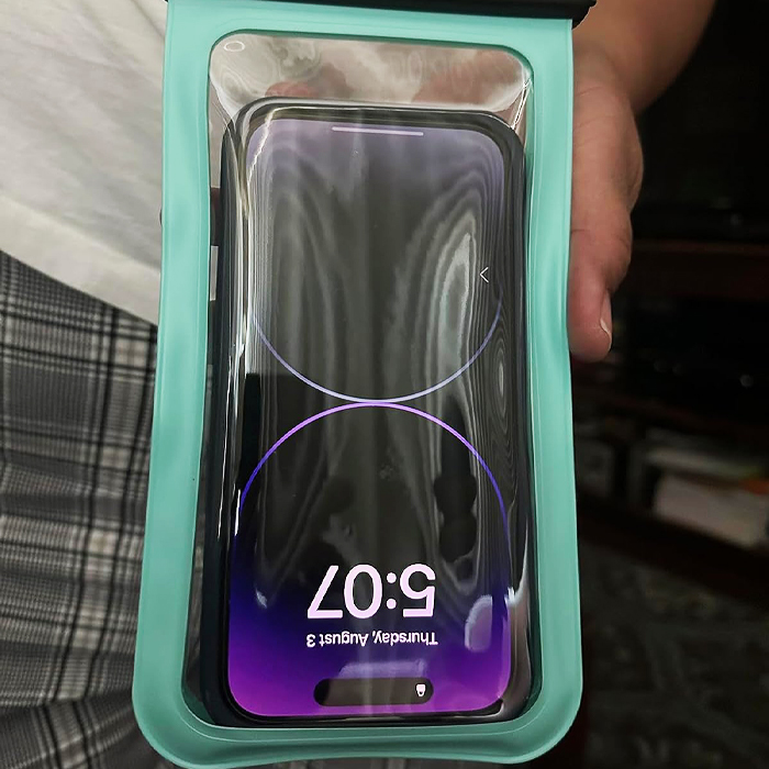 Waterproof phone pouch held by a person, ideal for traveling light and smart.