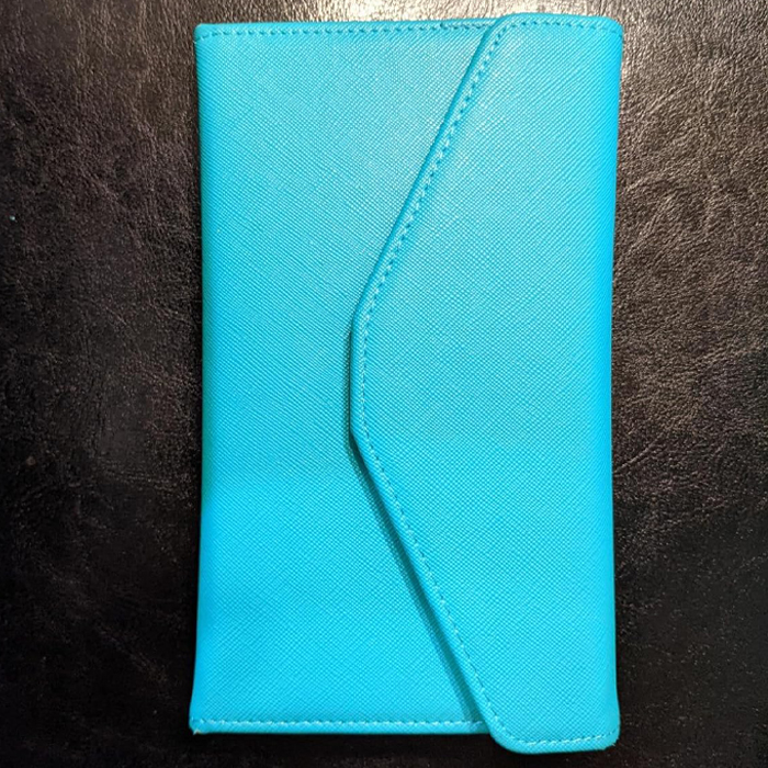 Turquoise travel wallet on a dark background, ideal for light and smart packing on vacation.