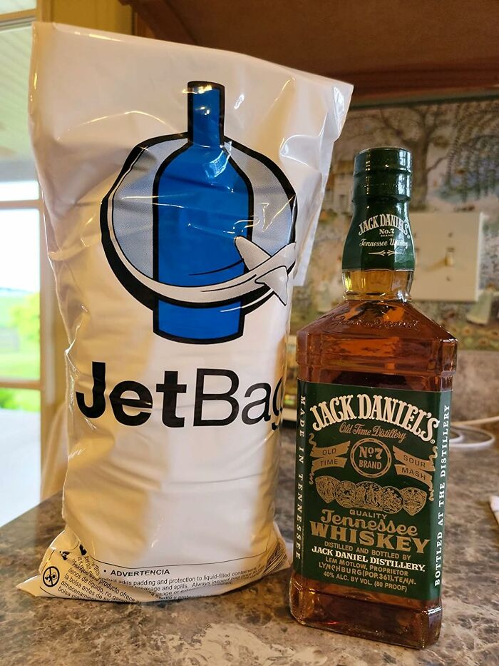 JetBag and Jack Daniel's whiskey bottle on a counter, ideal products for traveling light and smart.