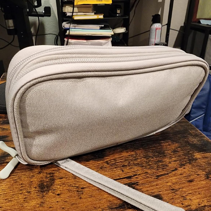 Gray travel toiletry bag on a wooden table, ideal for vacations and smart packing.