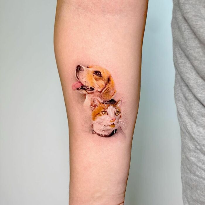 Tattoo of a dog and cat on forearm, highlighting cute pet portrait artistry.