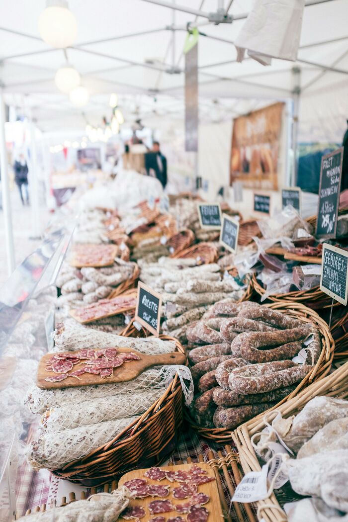 Market stall displaying various sausages and cured meats, showcasing frugal wins for saving money shoppers.