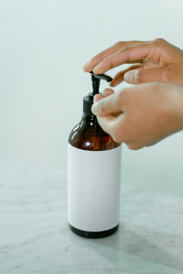 Hands dispensing liquid from a pump bottle, illustrating a simple frugal win for saving money.