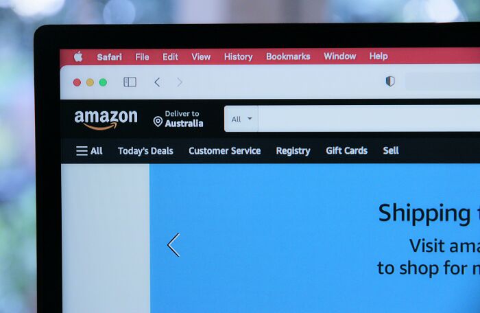 Amazon website open on a laptop showing navigation menu, focused on saving money and frugal wins.