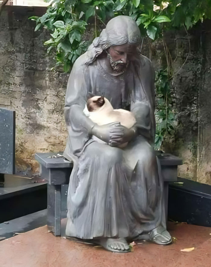 Statue of a seated figure holding a cat, illustrating blessed and godsent cats in a peaceful garden setting.