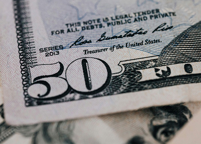 Close-up of a fifty-dollar bill representing unlikely events involving money and improbable experiences people encountered.