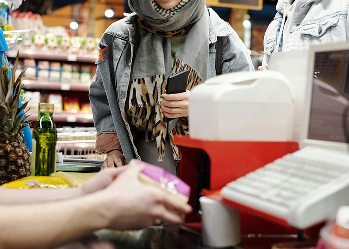 Customer at a checkout counter experiencing an unlikely event while making a purchase in a grocery store setting.