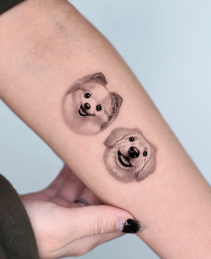 Cute pet portrait tattoos featuring two smiling dogs on a person's arm.
