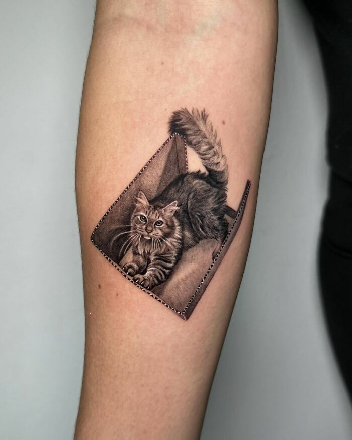 Cat portrait tattoo on forearm, showcasing detailed artistic skill in pet portrait tattoos.