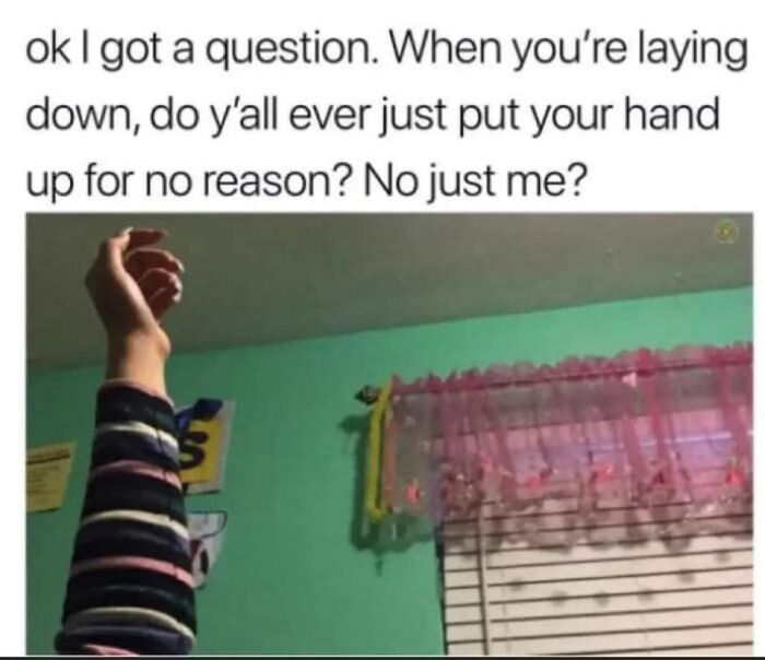 A humorous meme with text about randomly raising your hand while lying down, featuring a hand in the air.