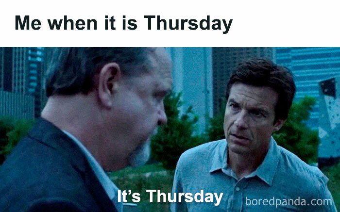 Two men in conversation, expressing the feeling of Thursday, with city buildings in the background.