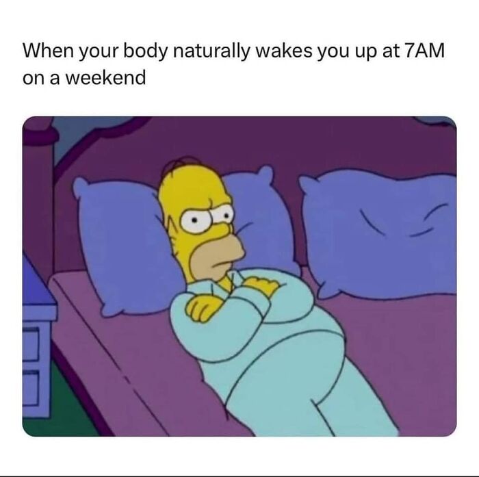 Homer Simpson in bed, looking annoyed, is a hilarious meme about waking up early on weekends.