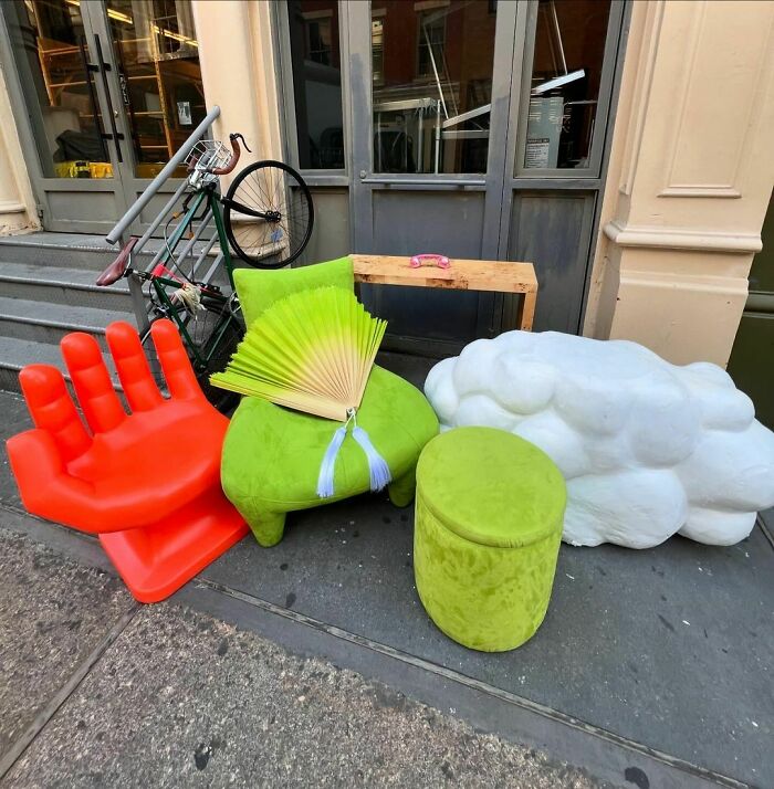 Colorful curb finds in NYC: red hand chair, green seat, and cloud sculpture await new owners on the stoop.