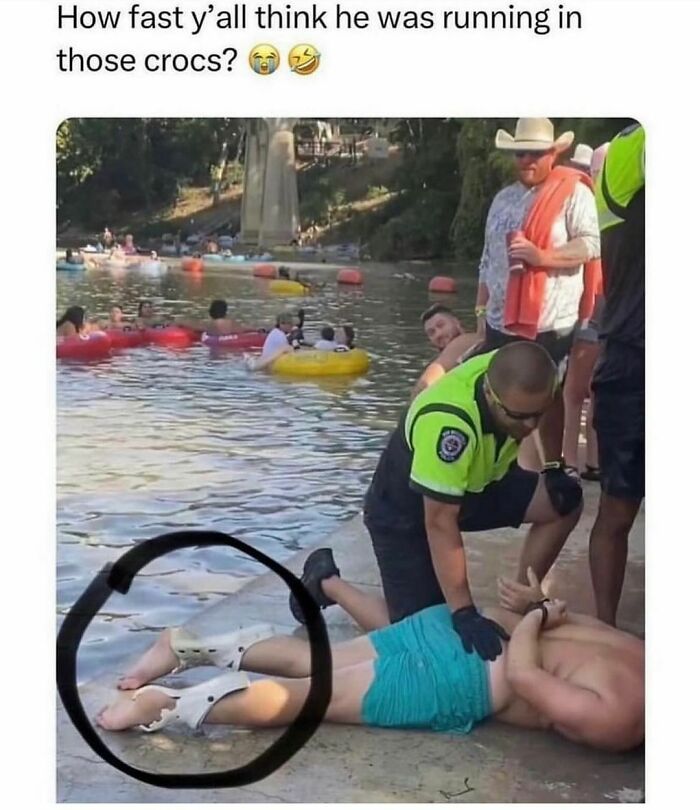 Officer assists man in crocs near a river, surrounded by people tubing. Random relatable meme moment captured outdoors.