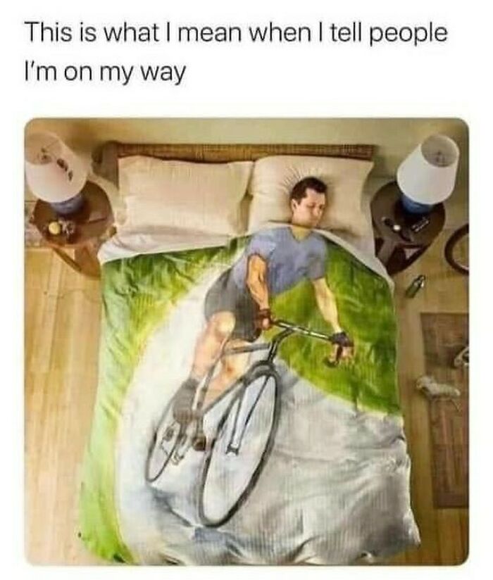 Man lying in bed under a bicycle-themed blanket, representing relatable memes humor.
