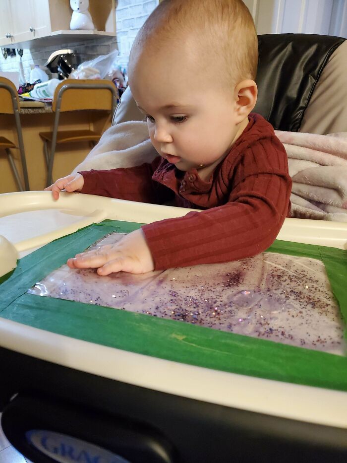 Use A Vaccuum Sealer To Seal Some Glitter And Water In A Bag And Use Painter's Tape To Stick It To The High Chair Table