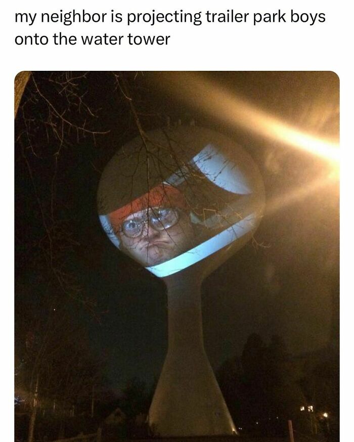 Water tower at night with a projected image of a person wearing glasses, reflecting young adults living interesting lives.