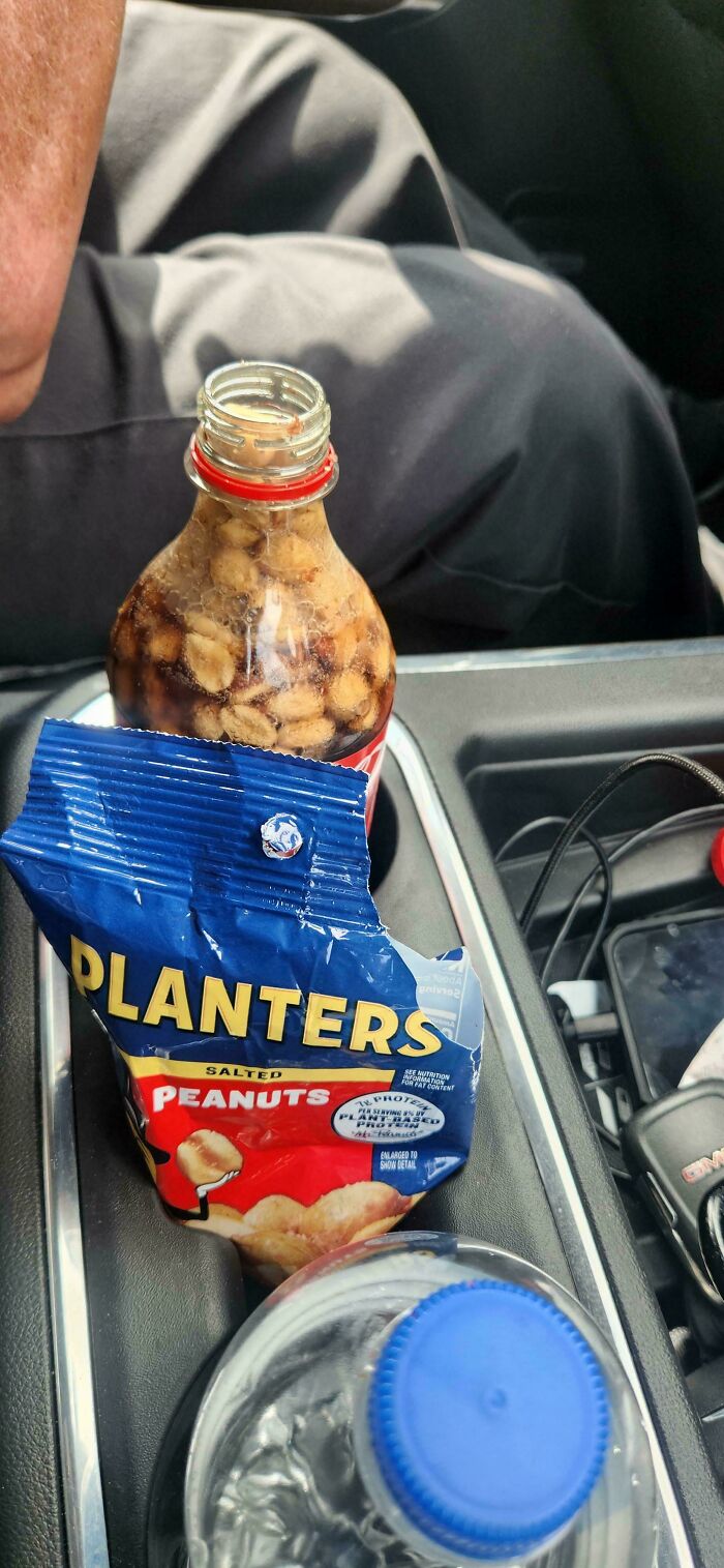 Peanuts floating in a cola bottle, next to a Planters peanuts pack, illustrating a bizarre dish concept.