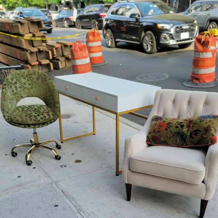 Street scene with a green chair, white desk, and beige armchair on the curb, showcasing Stooping NYC treasures.