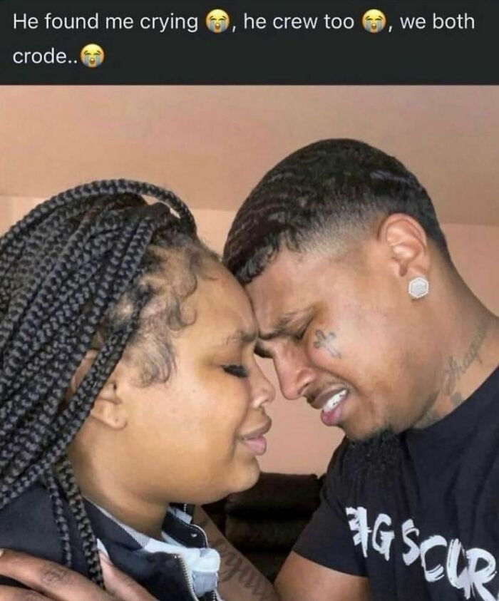 A couple with braided hair and tattoos leaning heads together, showing a raw and emotional moment in a random and cringe photo.