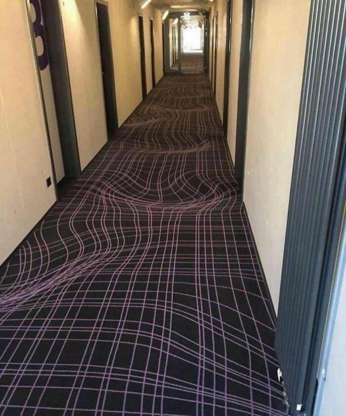 Hotel hallway with carpet creating a 3D optical illusion of waves, a random and cringe photo for unique sense of humor fans