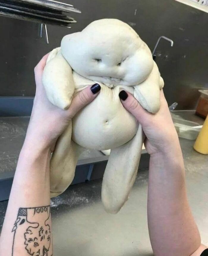 Person holding a funny dough figure resembling a small creature in a random and cringe photo with unique humor.