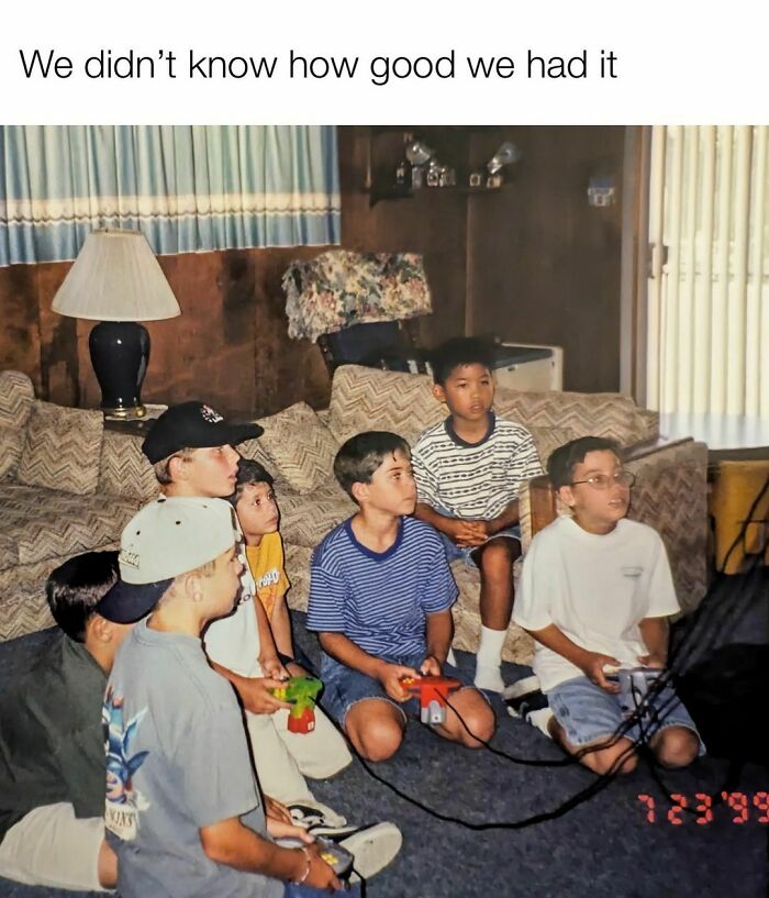 Group of kids sitting in a living room playing video games, evoking nostalgia with Tamagotchis and VHS tapes.
