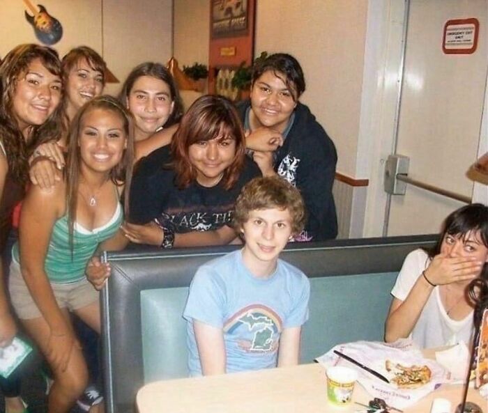 Group of friends at a diner booth, one person laughing, captioned by the weirdest Instagram account.