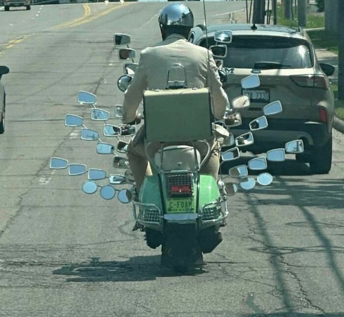 Man on a scooter with many mirrors, embodying weird Instagram aesthetics.