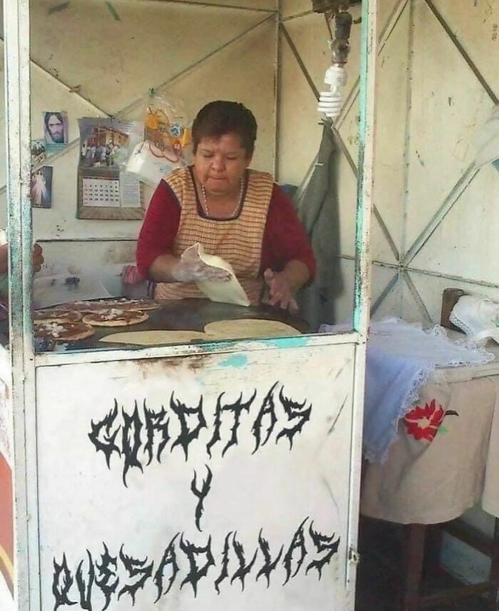 A woman prepares food at a small stand labeled "Gorditas y Quesadillas," featuring unique lettering, for Instagram account content.