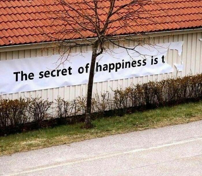 Banner on a shed reads "The secret of happiness is t" with torn edges, part of a weird Instagram account theme.