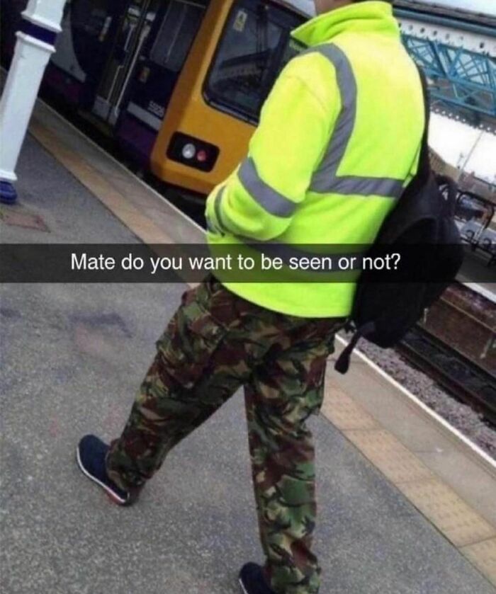 Person in a bright jacket and camo pants at a train station, featuring a humorous overlay text.