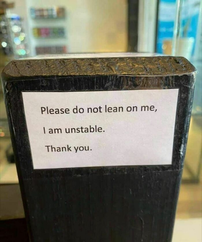 Sign on a pole reads, "Please do not lean on me, I am unstable," aligning with weird Instagram content.