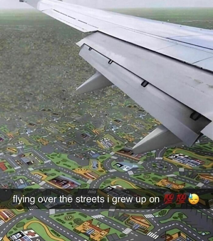 Airplane wing over a toy city street map, captioned "flying over the streets I grew up on," from weird Instagram account.