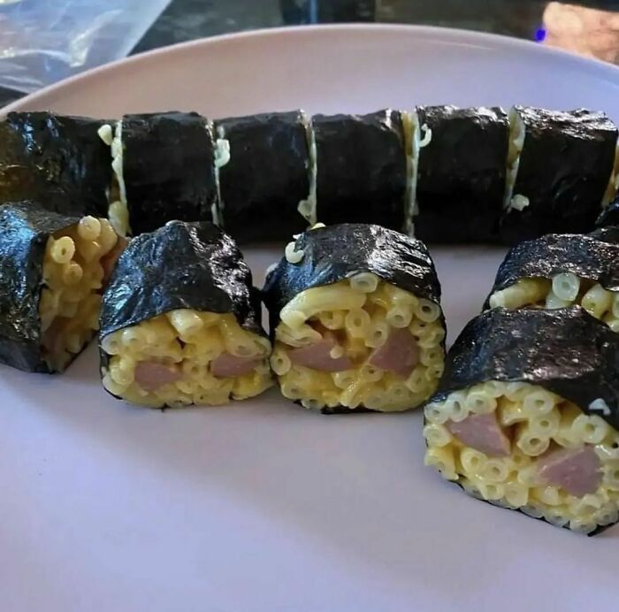 Unusual sushi rolls made with macaroni and sausage on a plate, showcasing weird Instagram content.