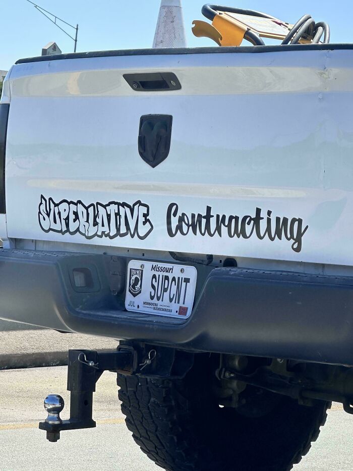 White truck with a misspelled Superlative Contracting sign and a personalized Missouri license plate showing a funny and awkward moment.