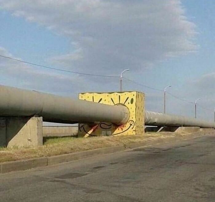 Pipe passing through a painted block with a spiral design, creating an awkward and painful visual effect.