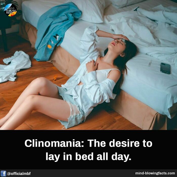 Woman sitting on the floor beside a bed, expressing clinomania, surrounded by casual clothes in a dimly lit room.