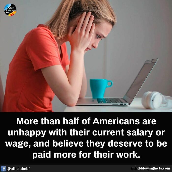 Woman in orange shirt looking stressed at laptop, illustrating amazing facts about Americans' salary dissatisfaction.