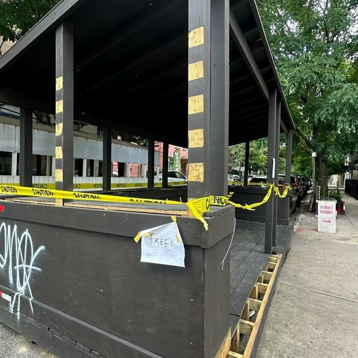 Free wooden structure on NYC curb, wrapped in caution tape, available for stooping enthusiasts to find.