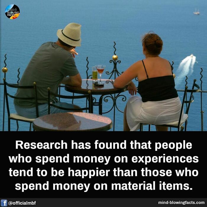 Two people sitting at a table overlooking the ocean with drinks, illustrating mind-blowing facts about happiness.