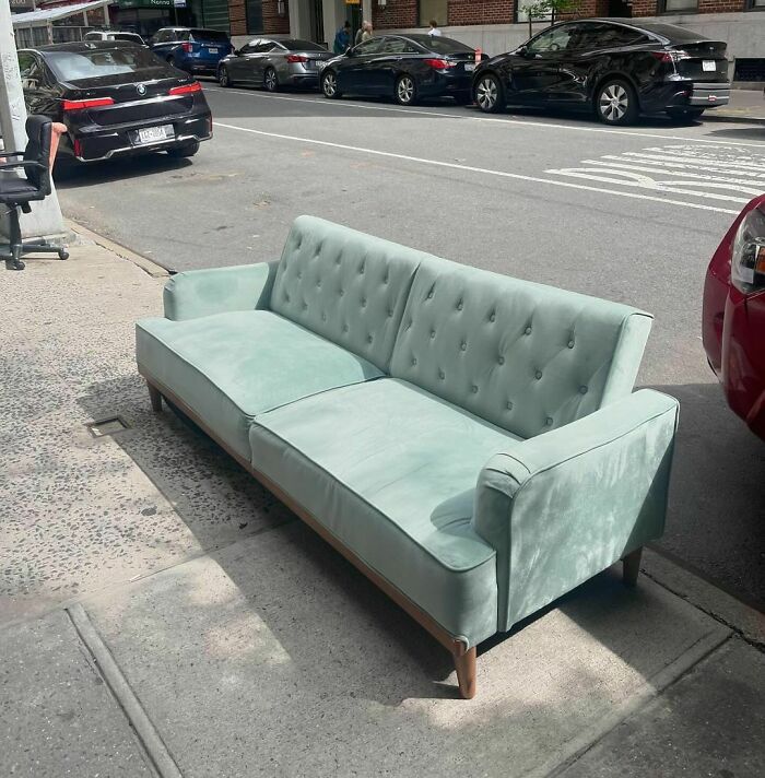 Green sofa on NYC curb, part of Stooping NYC: treasures left for others to find.